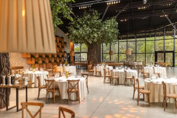 Decoração de casamento minimalista. Imagem de um salão com paredes de vidro e árvore dentro.
