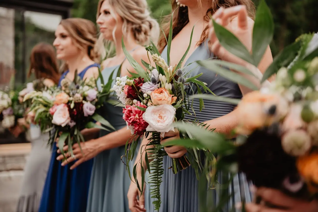 Imagem de madrinhas de casamento com buquê de flores nas mãos.