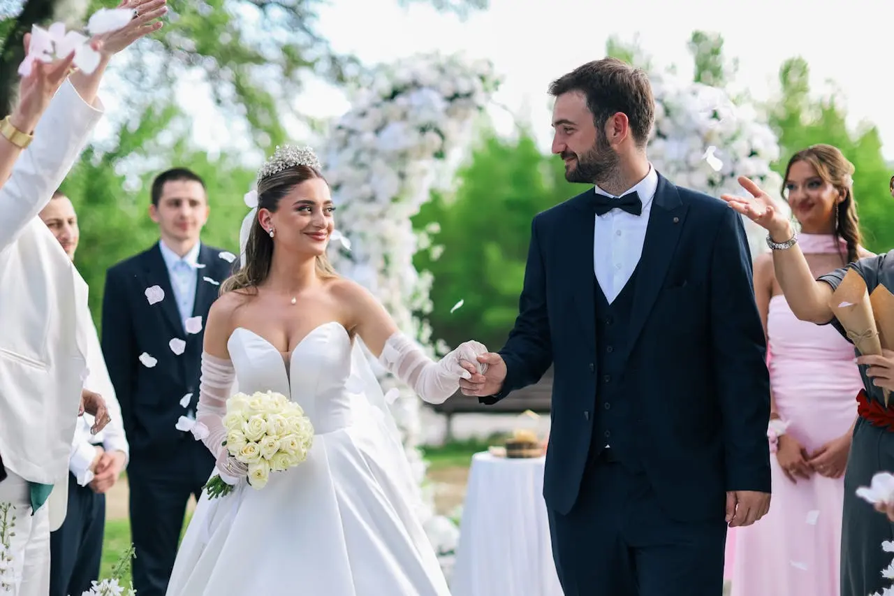 As melhores músicas para entrada do noivo em diferentes estilos Imagem de uma noiva e de um noivo saindo da cerimônia de casamento