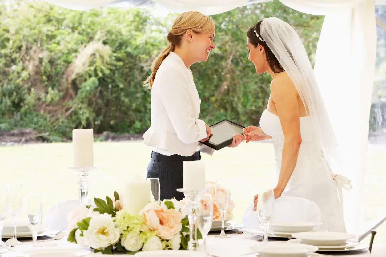 Quanto custa um cerimonialista para casamento pequeno, médio e grande Imagem de uma noiva em seu casamento conversando com a cerimonialista.