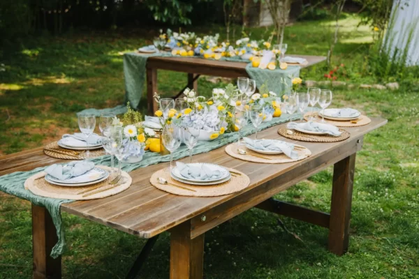 Decoração de casamento rústico. Mesa de madeira ao ar livre com limões e arranjos florais.