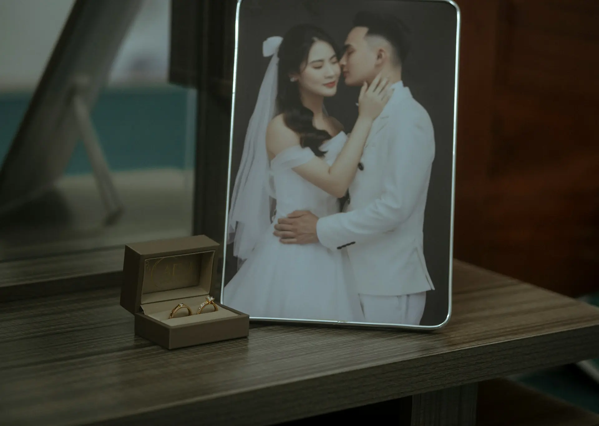 Como escolher o melhor site de casamento para organizar seu grande dia Fotografia dos noivos e uma caixa com aliança.