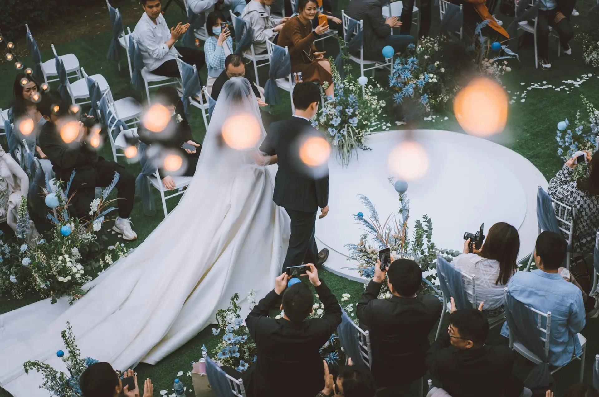 Quanto custa um site de casamento e o que considerar antes de criar o seu Imagem dos noivos entrando na cerimônia de casamento.