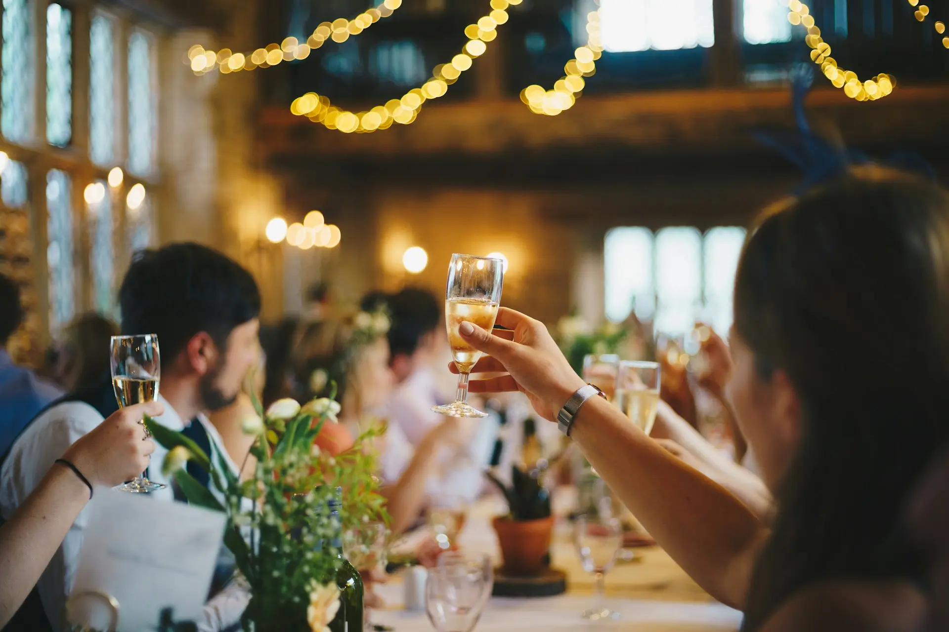 Convidados celebram casamento com taças de espumante à mesa