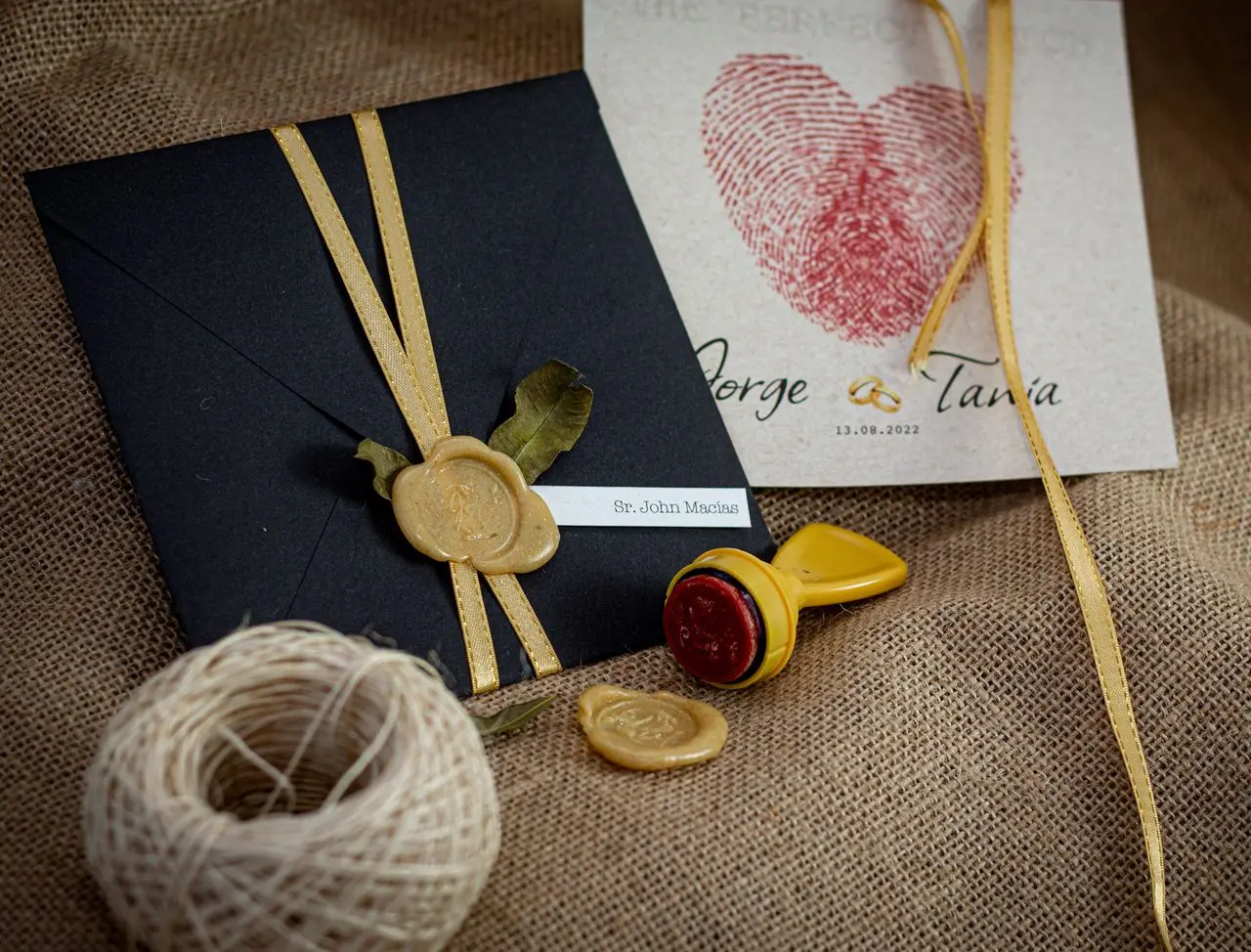 Site de casamento no convite: onde incluir e o que escrever Convite de casamento com envelope preto, lacre de cera dourado e fita de cetim.