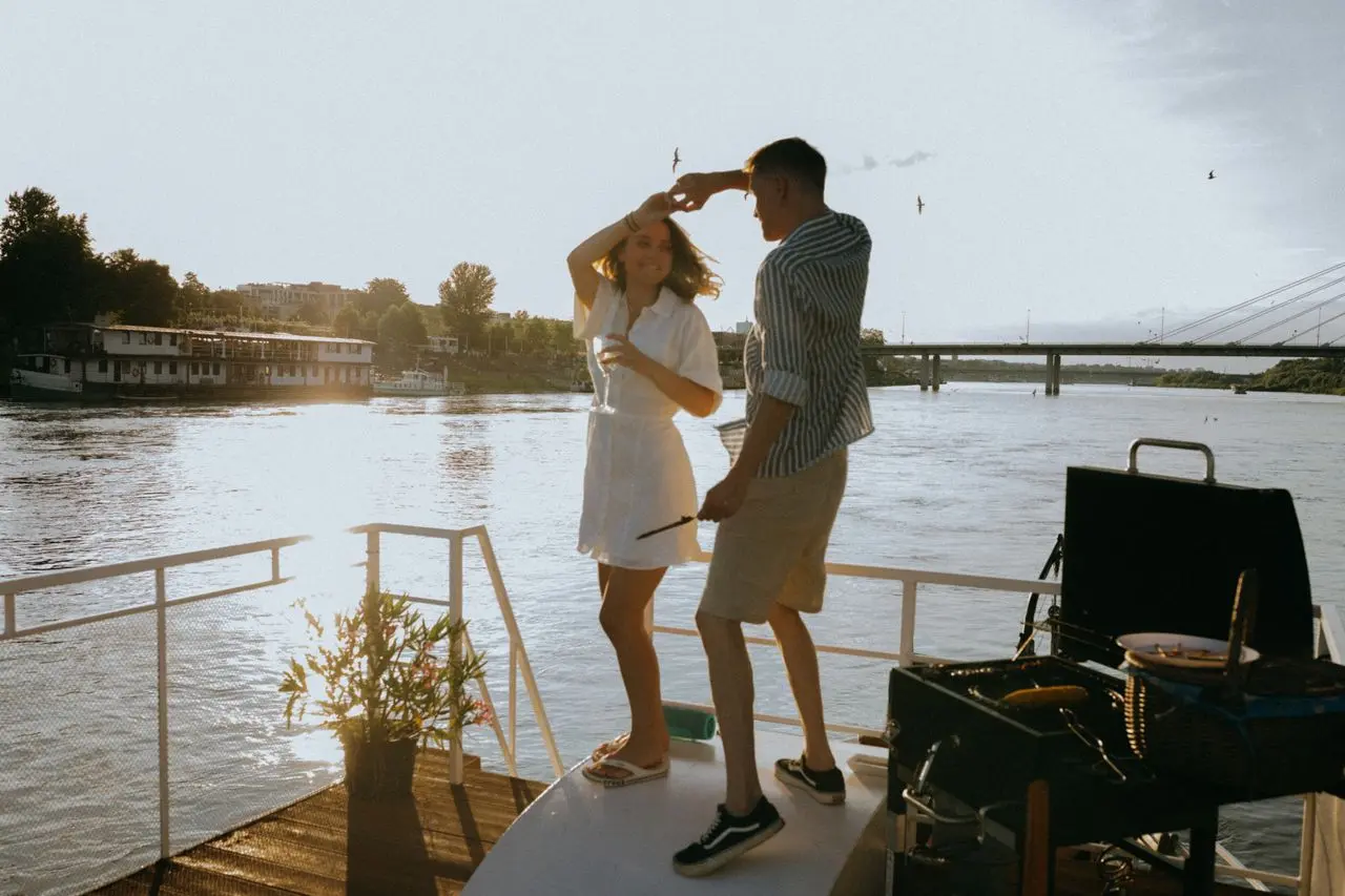 Casal dançando em um barco durante passeio ao pôr do sol.